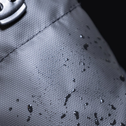 Close-up of a black bag with water droplets, highlighting water resistance.