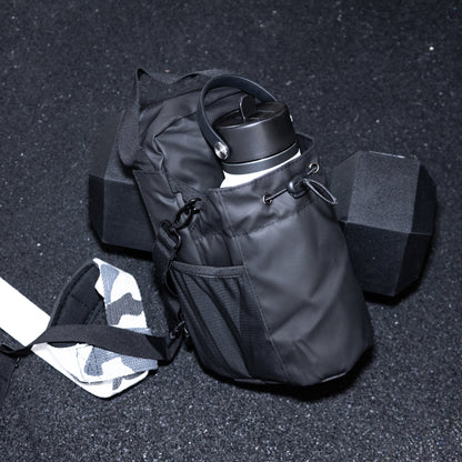 Black hydration pack with water bottle on a dark gym floor